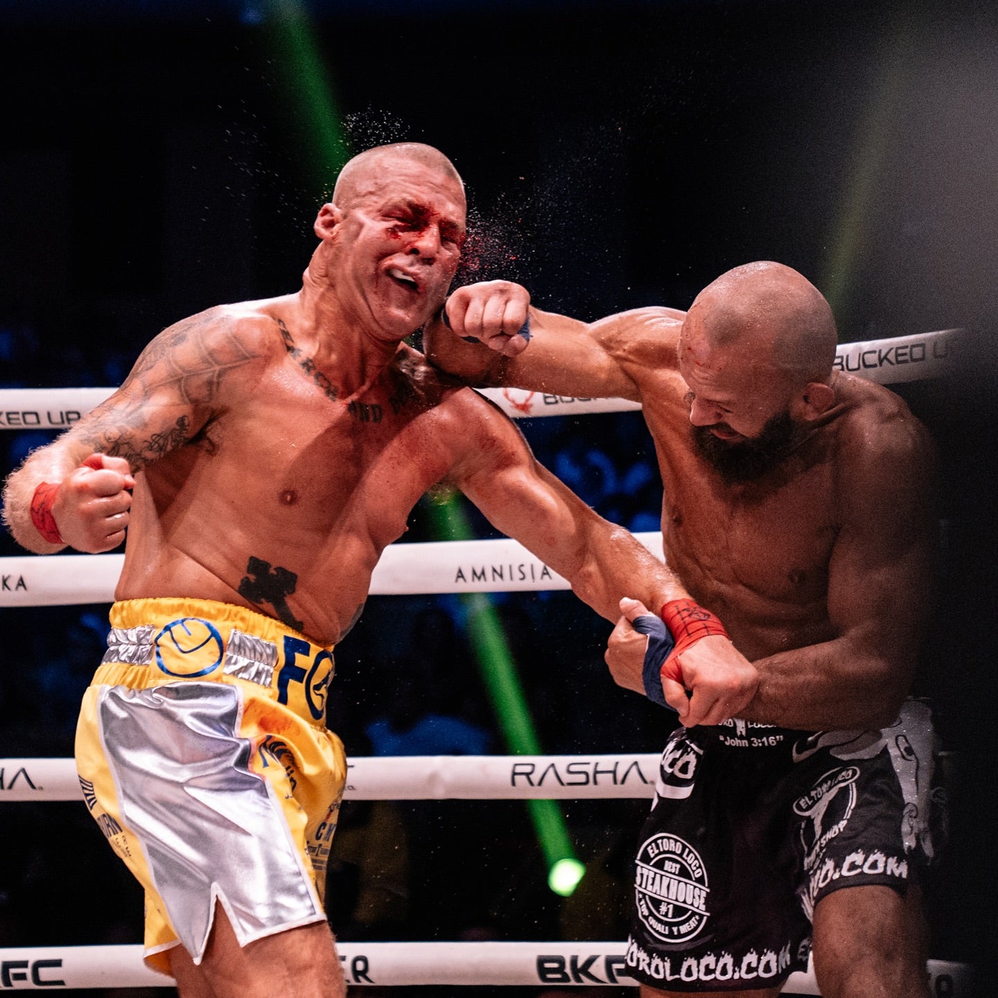 Two boxers in a boxing ring with one delivering a punch to the other.