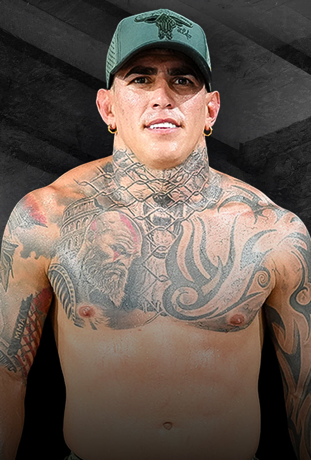 Man with tattoos wearing a green cap against a black background